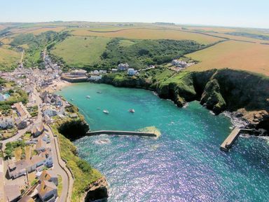 A coastal village with houses near a small bay with boats and cliffs at Mermaid Cottage in Port Isaac