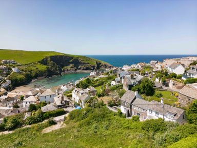 A coastal village with houses on hills and a bay with boats in the sea at Mermaid Cottage in Port Isaac