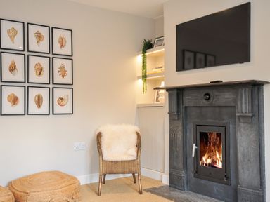 A living room with a fireplace and a television at Mermaid Cottage in Port Isaac