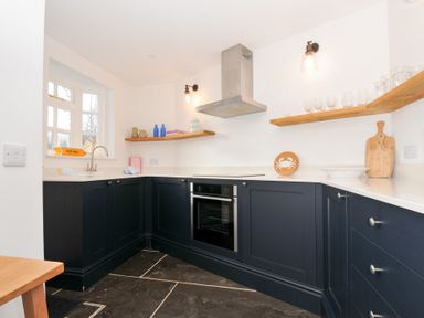 A kitchen with a sink and oven at Mermaid Cottage in Port Isaac