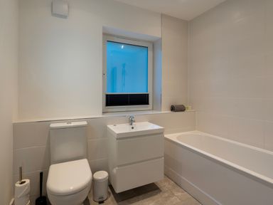 A bathroom with a toilet sink bathtub and window at Treen in St Ives