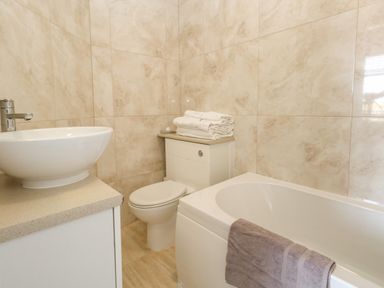 A bathroom with a bathtub a toilet and a sink at The Esplanade in Weymouth