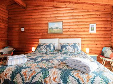 A bedroom with a bed with animal patterned bedding and folded towels on top at Rocksite in Kirkmichael Perth And Kinross