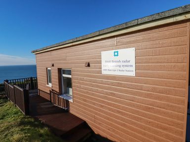 A wooden building with a sign about 1940 British radar early warning system by the sea at Sunset Sea View Chalet Millbrook