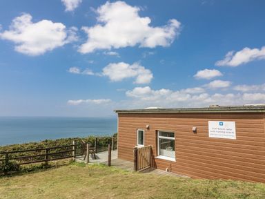 A building with a deck and ocean view at Sunset Sea View Chalet in Millbrook
