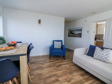 A living room with a dining table and chairs at Sunset Sea View Chalet in Millbrook