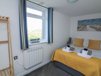 A bedroom with a bed and a window at Sunset Sea View Chalet in Millbrook