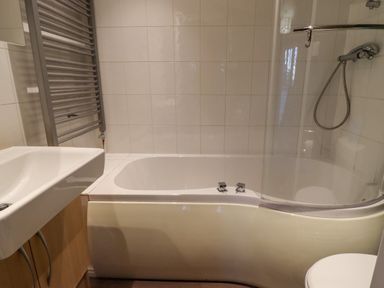 A bathroom with a bathtub a sink a shower and a heated towel radiator at Swinsty Lodge in Fewston near Darley