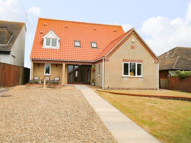 A house with a red tiled roof a gravel driveway and a paved walkway at Drifters in Winterton-On-Sea