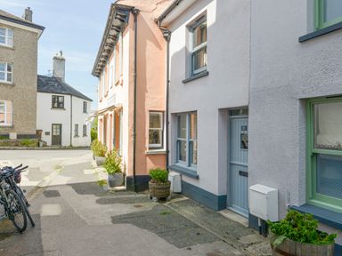 A street with buildings featuring windows and doors and bicycles parked on the sidewalk at The Cottage on The Square in Chagford