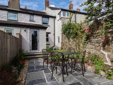 A garden with a table and chairs at The Cottage on The Square Chagford