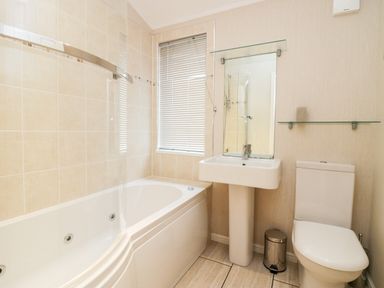 A bathroom with a bathtub shower sink mirror toilet and window blinds at Highfield Lodge Kirkstone 30 Limefitt Park near Troutbeck