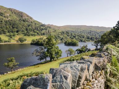 A lake surrounded by hills trees and a stone wall in the foreground at Highfield Lodge in Kirkstone 30 Limefitt Park near Troutbeck