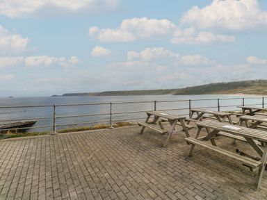 An outdoor seating area near the ocean at Harbour Studio in Sennen Cove