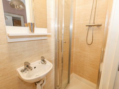 A small bathroom with a sink and a glass enclosed shower at Sunbeach Weymouth