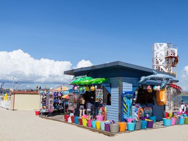A beach shop with inflatable toys and buckets on sand at Sunbeach in Weymouth