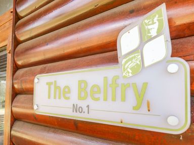 A wooden wall with a sign that reads The Belfry No 1 with fishing and golfing icons