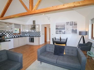 A living room with a sofa and dining area at Lodge 1 South Hykeham