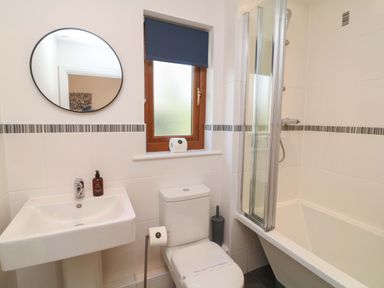 A bathroom with a sink, toilet, shower, and bathtub at Lodge 1 in South Hykeham