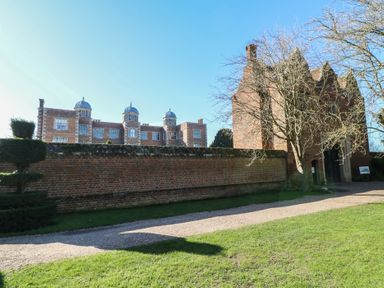 An outdoor view of a historical building and surrounding garden at Lodge 24 in South Hykeham