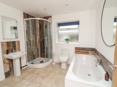 A bathroom with a bathtub, shower, toilet, and sink at Lodge 24 South Hykeham