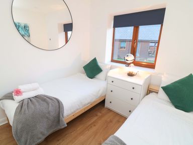 A bedroom with two single beds and a bedside table at Lodge 3 in Thorpe-On-The-Hill
