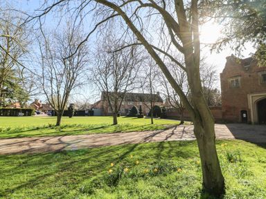 An outdoor view of a house with trees and a driveway at Lodge 4 South Hykeham