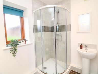 A bathroom with a shower, sink, and window at Lodge 7 in South Hykeham