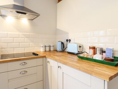 A kitchen countertop with a stove kettle toaster and condiment jars at The Brambles in Polstead