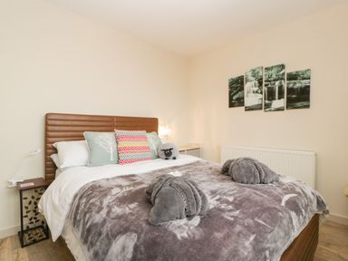 A bedroom with a bed with multiple pillows and folded towels on the blanket at Palace Bungalow in St Weonards