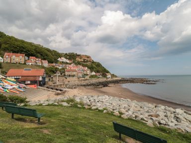 A beach with kayaks and houses at Primrose Lodge in Runswick Bay near Staithes
