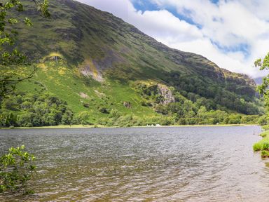 A lake with trees and a hill in the background at Tan Y Coed - Nasareth Nasareth near Penygroes