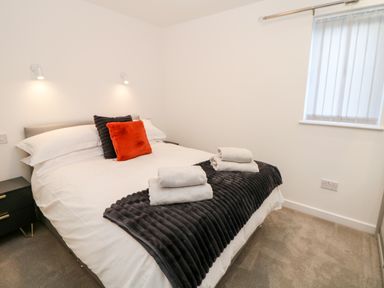 A bedroom with a double bed with pillows and folded towels on a blanket at Harry's Lodge in Ashover