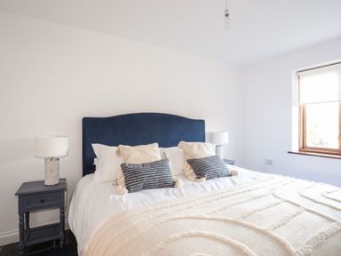 A bedroom with a bed and two bedside tables with lamps at Ynys Faelog Cottage in Ynys Faelog near Menai Bridge