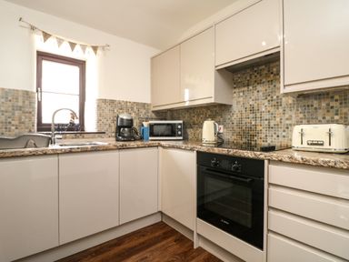 A kitchen with cabinets countertop oven sink coffee maker microwave kettle and toaster at The Old Piggeries in Gulval near Penzance