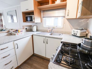 A kitchen with a sink microwave kettle toaster and stove at Forest Star in Cayton