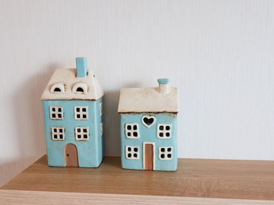 Two blue and white ceramic house-shaped ornaments on a wooden surface against a white wall at Forest Star in Cayton