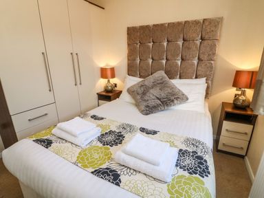 A bedroom with a double bed and bedside tables with lamps at Dream Catcher Lodge in Carnforth