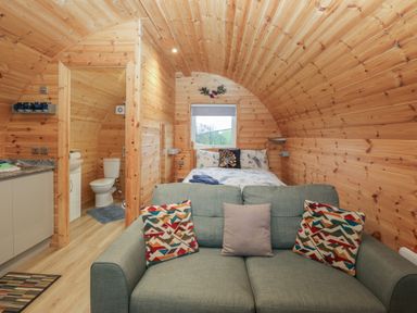 A bedroom with a sofa and bed at Holly in Ulverston