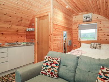 A bedroom with a sofa and kitchen area at Willow in Ulverston
