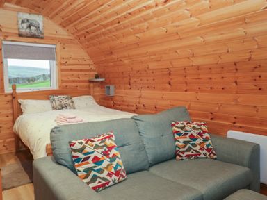 A bedroom with a bed and sofa at Willow in Ulverston