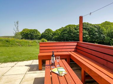 A garden with outdoor seating and a bottle on a table at Willow in Ulverston