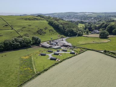 An aerial view of a farm surrounded by fields and hills at Willow in Ulverston