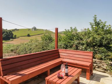 An outdoor seating area with a table and bench at Rowan in Ulverston