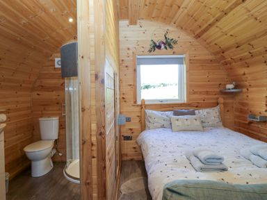 A bedroom with a bed and attached bathroom at Cherry in Ulverston
