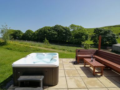 An outdoor area with a hot tub and seating at Cherry in Ulverston