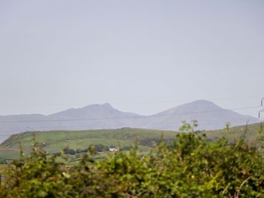 A view of mountains and grassland with power lines in the foreground at Cherry in Ulverston