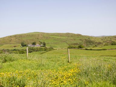A landscape with a house and hills at Cherry in Ulverston