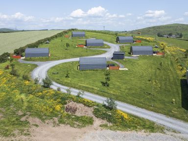 An outdoor area with cabins and a gravel road at Cherry in Ulverston