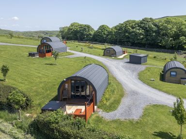 An outdoor view of cabins on a grassy area at Cherry in Ulverston
